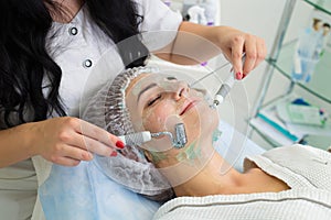 The patient receives procedure Darsonvald. His face is smeared with gel. photo