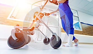 Patient on rollator with hand brakes moving in hospital