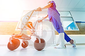 Patient on rollator with hand brakes moving in hospital