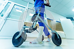 Patient on rollator with hand brakes moving in hospital