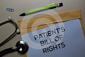 Patient`s Bill of Rights text on document above brown envelope and stethoscope. Healthcare or medical concept