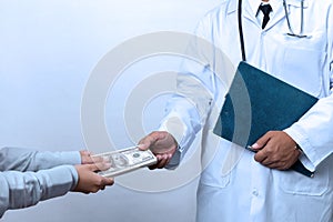 Patient`s hand paying a money to doctor