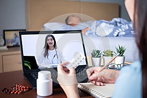 Patient`s relatives use video conference, make online consultation with doctor on notebook computer, ask doctor about illness photo