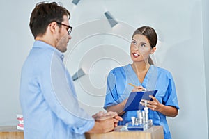 Patient signing documents in dental clinic