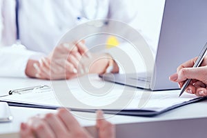 Patient signing medical contract. Female doctor explains how to fill medical form.