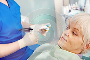 Patient sitting on dental armchair with doctor