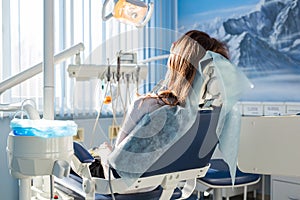 Patient sitting on dental chair, waiting for her dentist. Stomatology medicine, dental care, prevention, health concept.