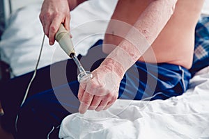 Nurse holds an apparatus for the treatment of electric shock Darsonval photo