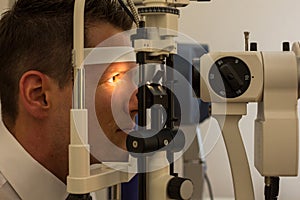 Patient at slit lamp of optician or optometrist photo