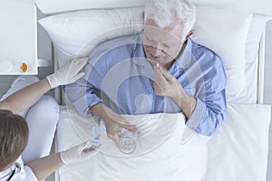 Patient taking pill with glass of water