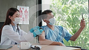 Patient taking a selfie portrait with while a doctor is vaccinating.