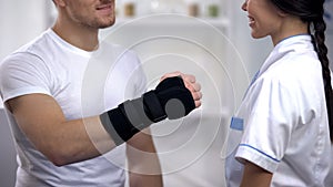 Patient in titan wrist brace showing hand doctor, rehabilitation after operation