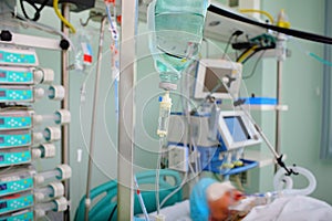 Patient under IV drip in an intensive care unit, connected to life-support devices