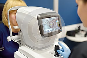 Patient during visit to optometrist for microscopic analysis of eyelids, sclera, conjunctiva, iris, lens, cornea. Examining of photo