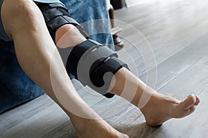 Patient wearing knee brace support after injury and surgery. Healthcare and medical concept