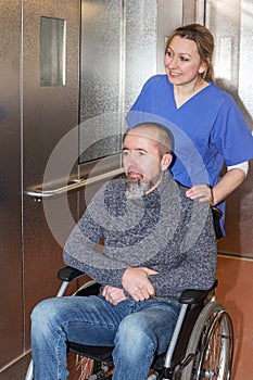 patient in wheelchair and nurse in elevator