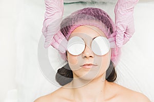A patient woman with closed eyes lies in the doctor`s office. Cosmetic procedures in cosmetology office. Face of the