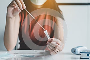 Patient woman using a covid-19 self test rapid antigen testing kit at home