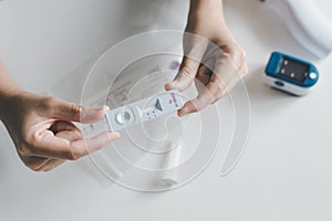 Patient woman using a covid-19 self test rapid antigen testing kit at home