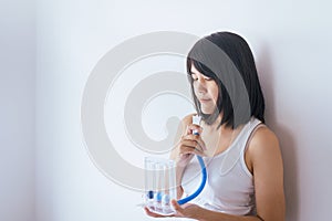 Patient woman using incentivespirometer or three balls for stimulate lung on white blackground