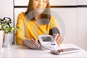 Patient woman using blood pressure & heart rate monitors in yourself at home