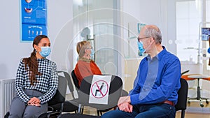 Patients with masks talking sitting on chairs keeping social distance