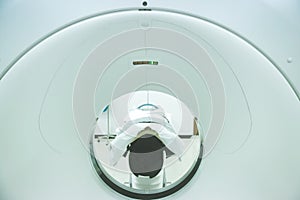 Patients screening on CT scanner. Man Undergoing CT Scan While Doctor`s Using Computers.