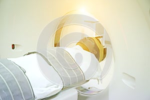 Patients screening on CT scanner. Man Undergoing CT Scan While Doctor`s Using Computers.