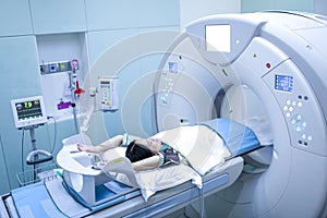 Patients screening on CT scanner. Man Undergoing CT Scan While Doctor`s Using Computers. Examining man in CT scanner. Computer use
