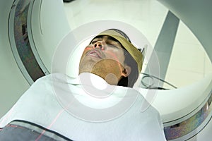 Patients screening on CT scanner. Man Undergoing CT Scan While Doctor`s Using Computers.