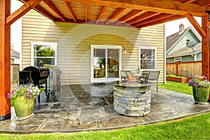 Patio area with tile floor and stone trimmed fire pit