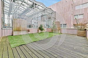 a patio with a green lawn and a glass greenhouse