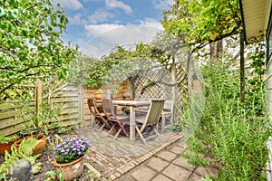 a patio with a table and chairs in a garden