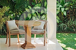 Patio with two wooden chairs and table in the garden