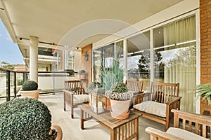 a patio with wooden furniture and potted plants