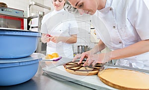 Patissier women working on fruit cake photo