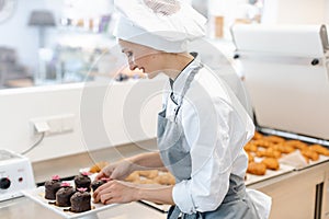 Patissier working on little chocolate desserts photo