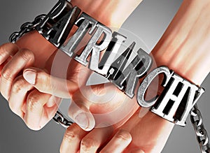 Patriarchy, social impact and its influence - a concept showing a person`s hands in chains with a word Patriarchy as a symbol of photo