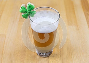 Patrick day glass of light unfiltered beer and cookies with green clover photo