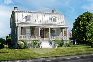 Patrimonial white house with Mansard metal roof in Laval Quebec