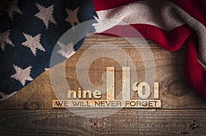 A scarf with the colors of the American flag on a wooden table and an inscription in memory of September 11th. Patriot day 2019