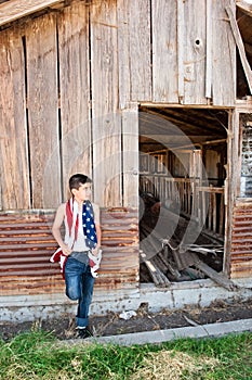 Patriotic boy and old barn