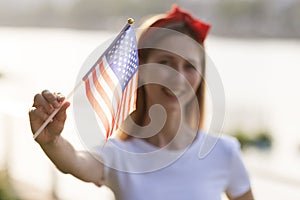 Patriotic holiday. Happy family, mother and daughter with American flag outdoors on sunset. USA celebrate independence