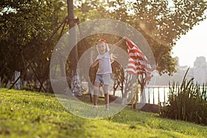 Patriotic holiday. Happy family, mother and daughter with American flag outdoors on sunset. USA celebrate independence