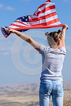 Patriotic holiday. Happy kid, cute little child girl with American flag. USA celebrate 4th of July.