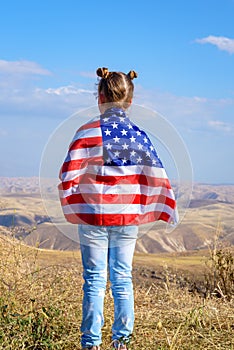 Patriotic holiday. Happy kid, cute little child girl with American flag. USA celebrate 4th of July.