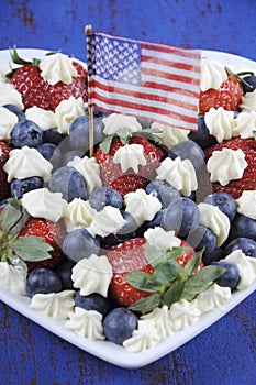 Patriotic red, white and blue berries with fresh whipped cream stars and USA flag.