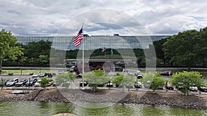 Patriotic Scene: American Flag Waving in Front of Corporate Office Building. Proudly Displayed Flag in Business Center