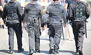 patrols of four policemen in riot gear with flak jackets and bat