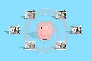 . Pattern of American dollar banknotes and pink piggy bank on bright blue background. The concept of financial savings and